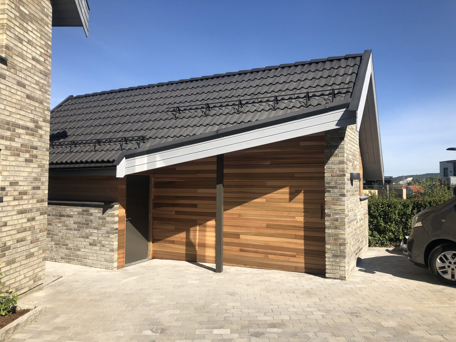 Ferdig bygget garasje med stein og treverk.