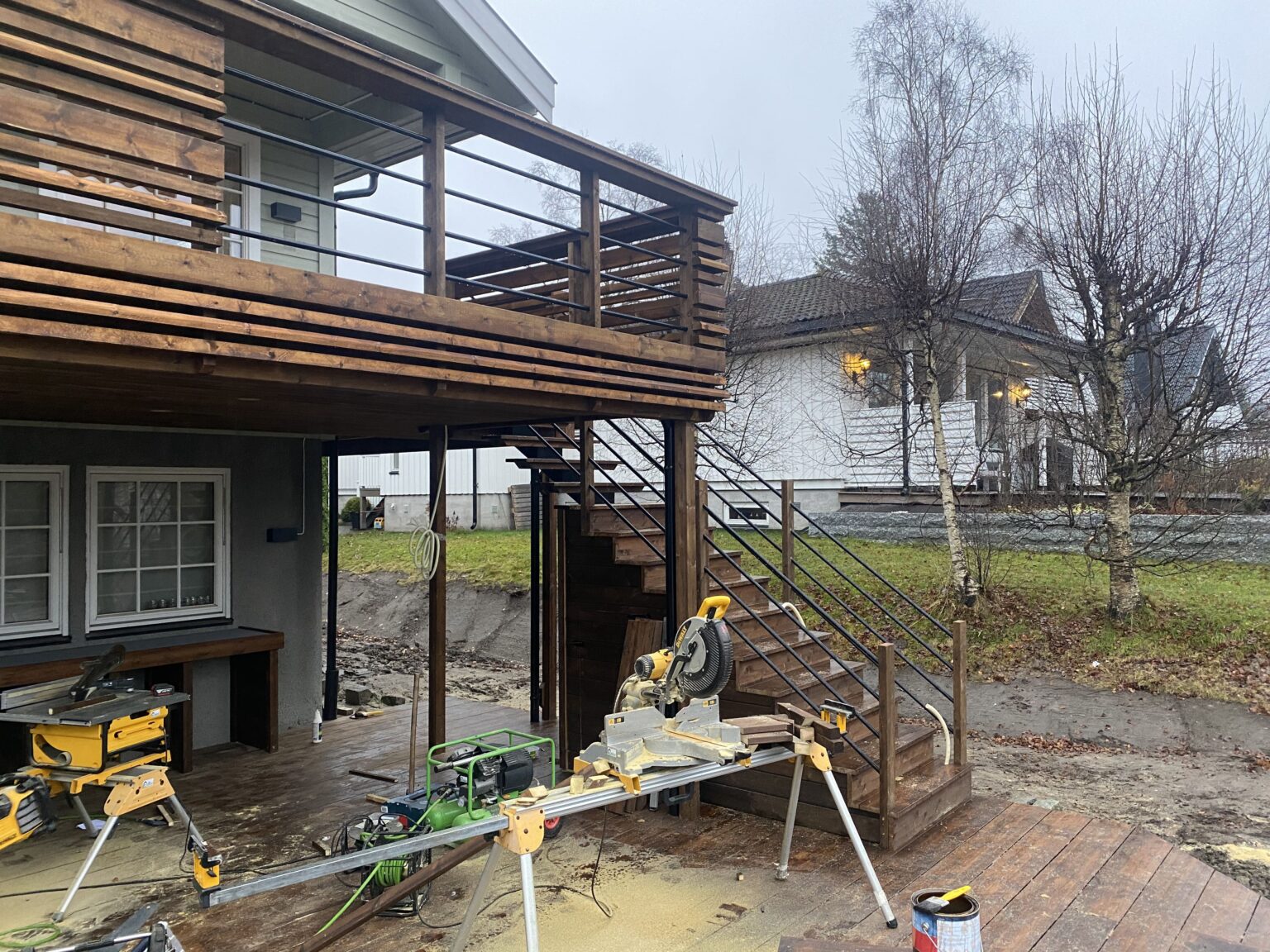 Sag som står foran trapp og veranda under bygging.